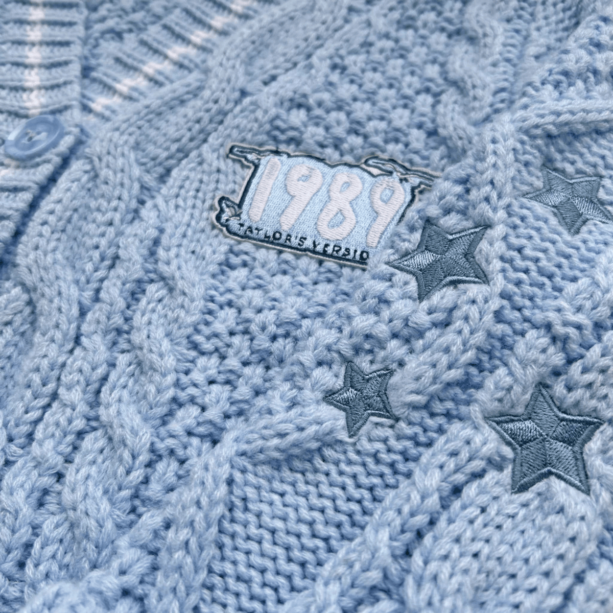 Close-up of a blue knitted fabric with '1989' and star designs.