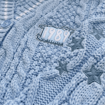 Close-up of a blue knitted fabric with '1989' and star designs.