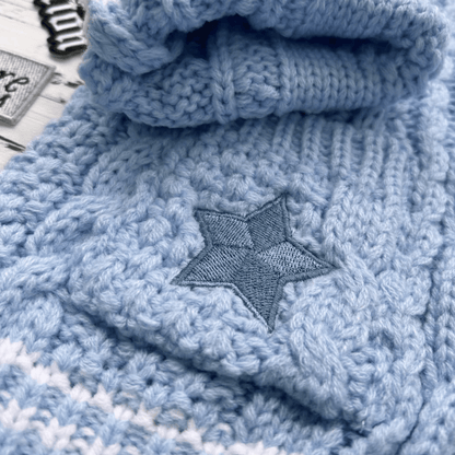 Folded blue knitted blanket with a star pattern on a white background