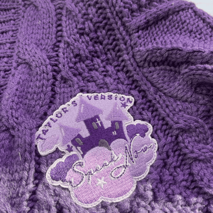 Purple textured fabric with a castle-themed patch featuring text.