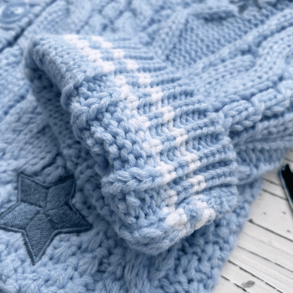 Close-up of a blue knitted blanket with a star pattern on a wooden surface