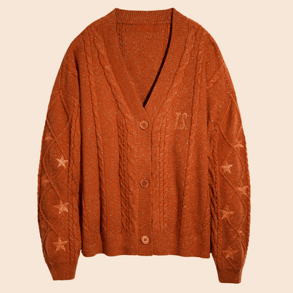 Showgirl Orange knit cardigan with star patterns on a beige background